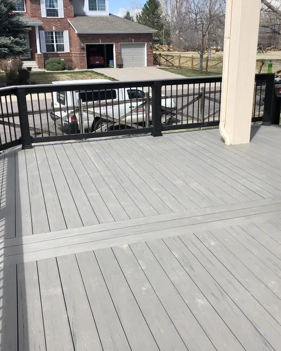 New gray deck with black metal railing seen from the corner