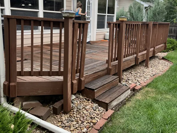 Phipps deck before: dark brown deck and railings beside a sunroom