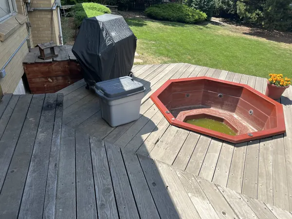 Richard deck before: gray, weathered boards around an old sunken hot tub