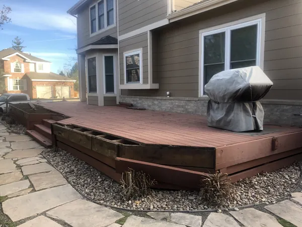 Samuels deck before: low red-stained deck with failing skirting