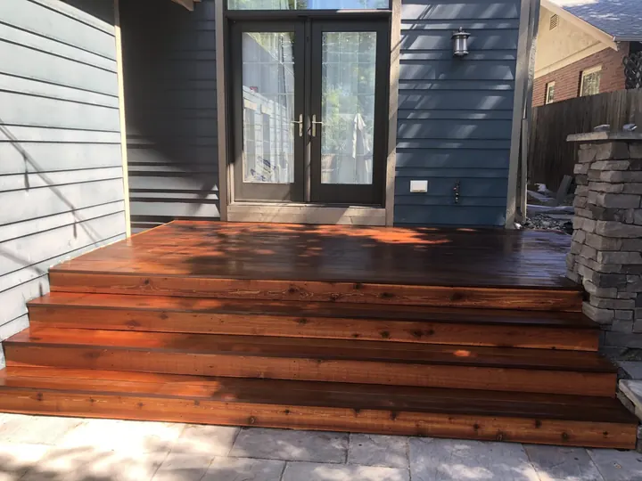 Freshly stained cedar steps and landing below a pair of French doors